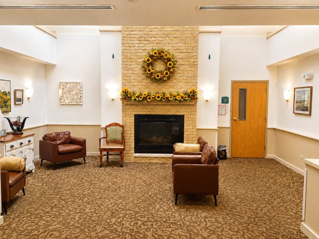 Community lobby with fireplace, comfortable seating, and sunflower decorations